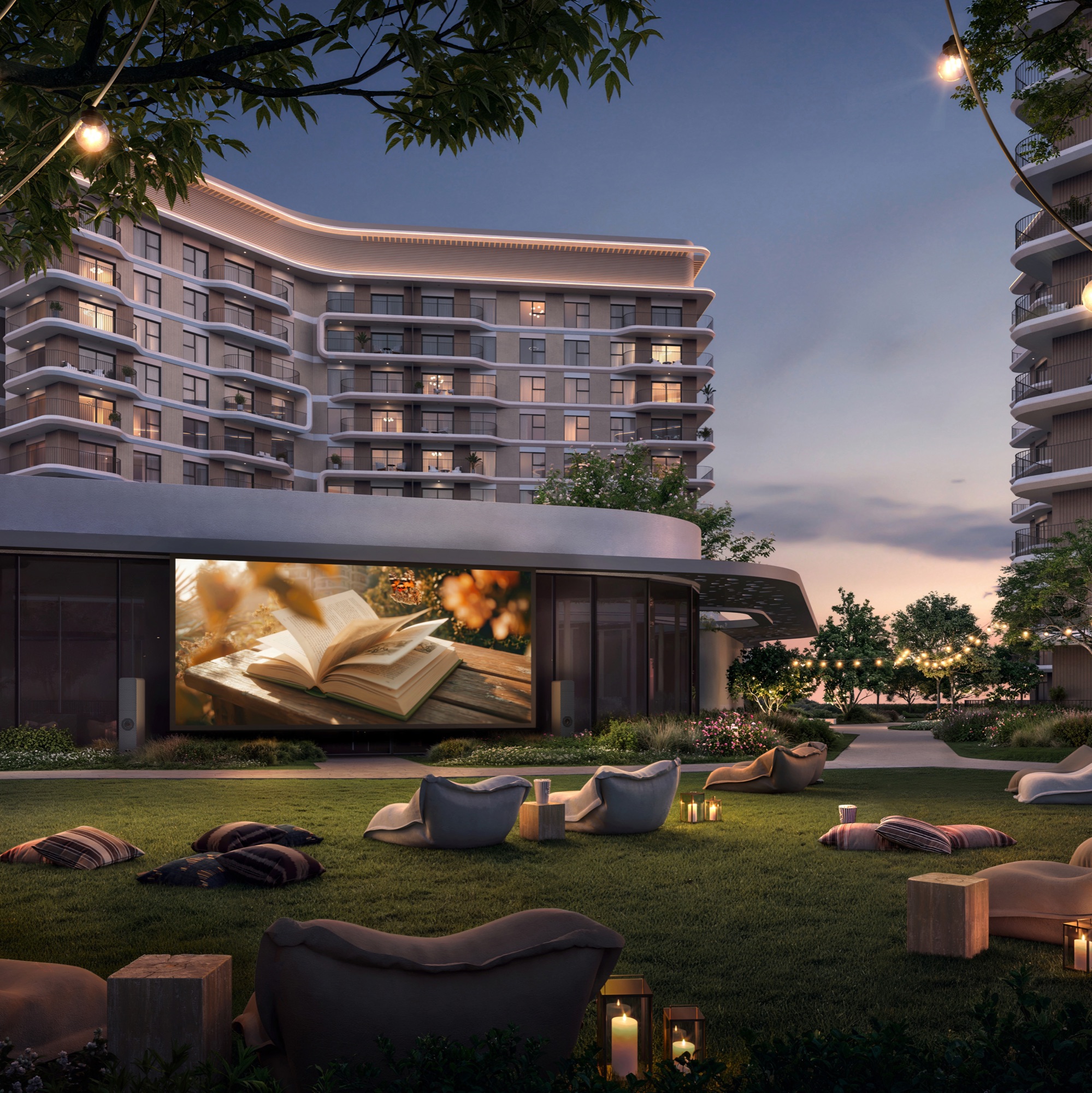 Yas Park Place Aldar Yas Island Abu Dhabi outdoor cinema lawn at dusk with bean bags beneath illuminated towers
