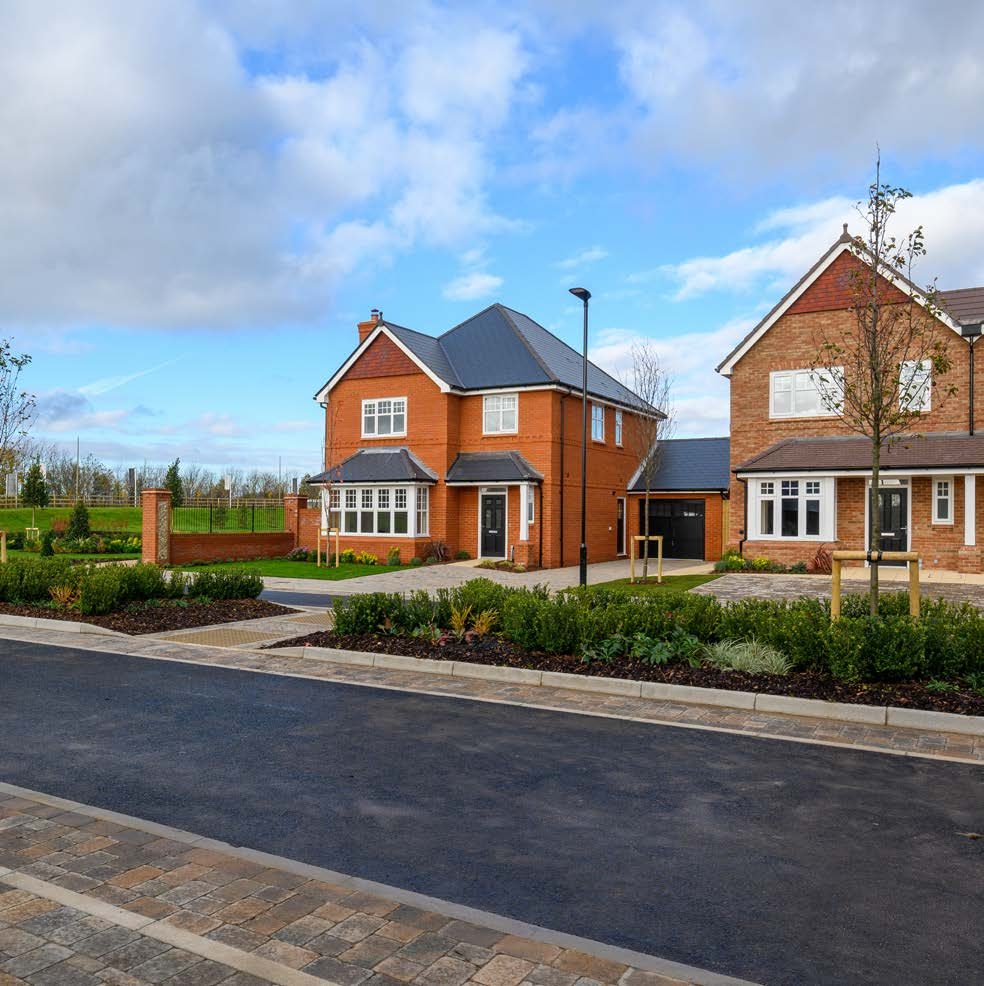 Photography of completed Berkeley Homes family houses at a nearby Milton Keynes scheme with red-brick facades and landscaped street planting