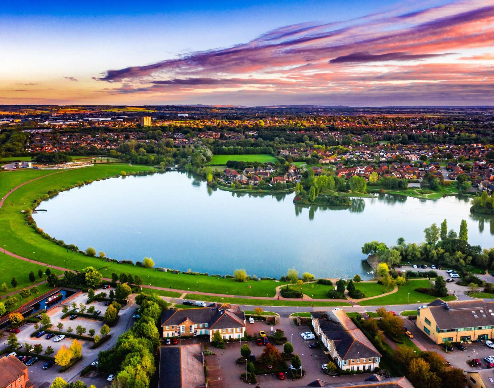 Milton Keynes Furzton Lake sunset aerial photograph showing lakeside homes, walking paths and city skyline