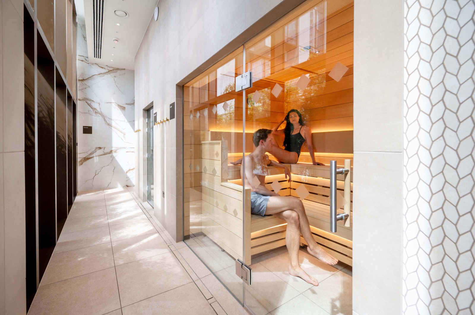 Harcourt Gardens South Quay Plaza Canary Wharf E14 Bamboo Sanctuary spa entrance with veined marble walls, honeycomb tile detailing and glass-fronted sauna at The Quay Club