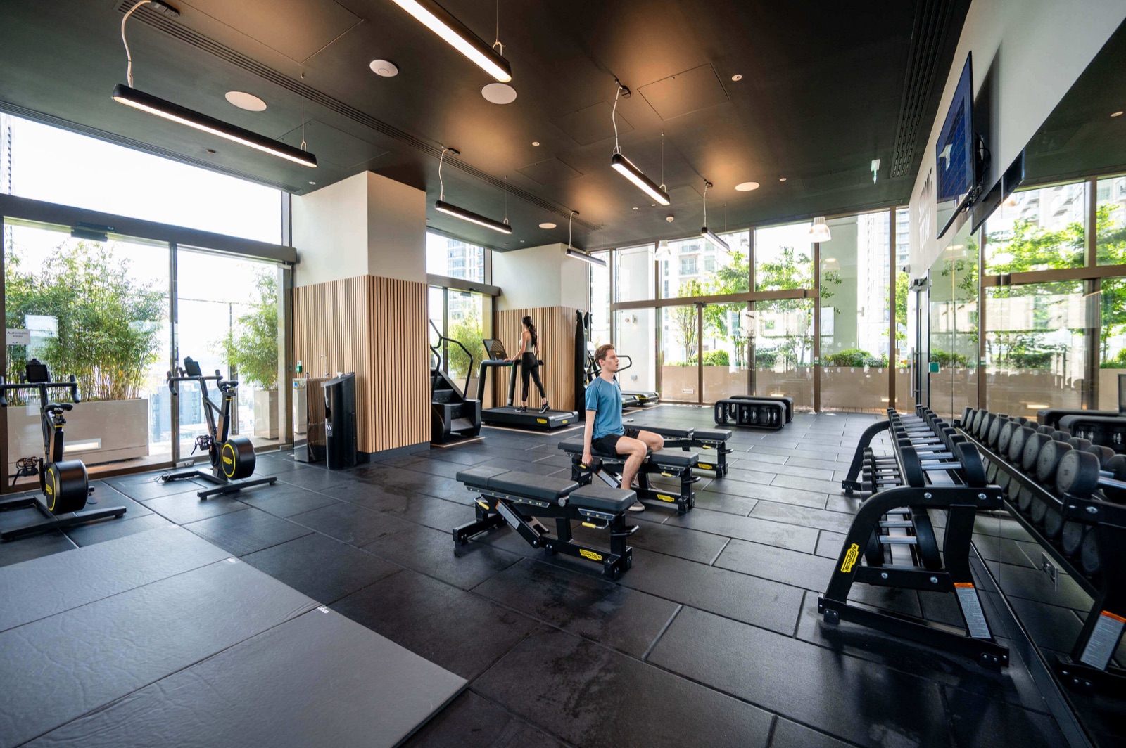 Harcourt Gardens South Quay Plaza Canary Wharf E14 residents gym with Technogym treadmills, exercise bikes, free-weights area and floor-to-ceiling glazing onto the planted gardens